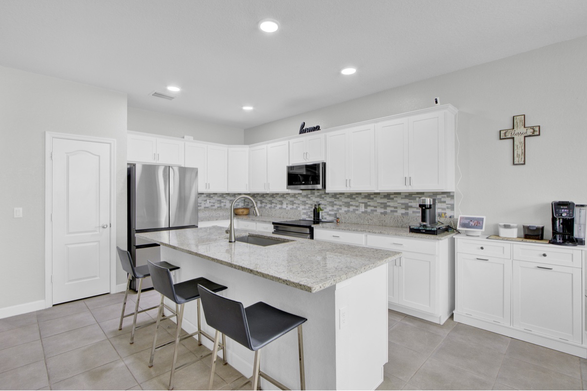 Renovated white kitchen with island and bar seating